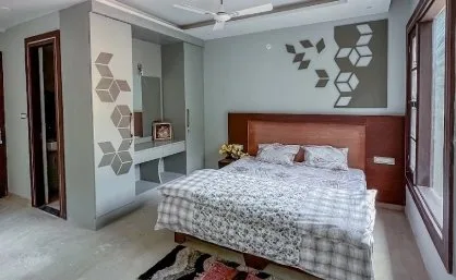 Double room with a patterned feature wall and dressing unit