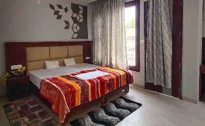Double bed with a striped blanket beside a large window