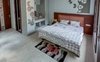 Bright double room with a padded headboard and rug