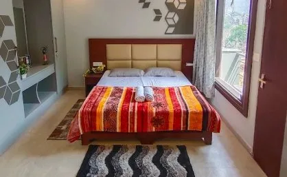 Double room with a colourful bedspread and folded towels