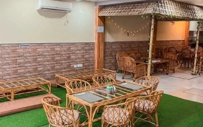 Cane tables leading to a thatched corner with string lights