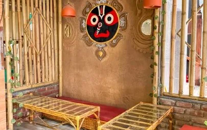 A bamboo nook with a Jagannath mask on a mud-plastered wall