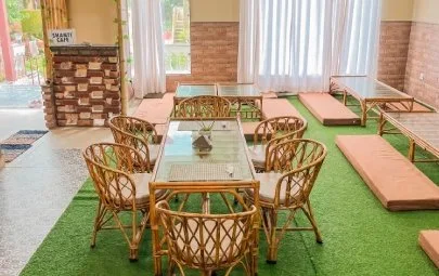 Cane chairs and floor seating on green matting in the cafe