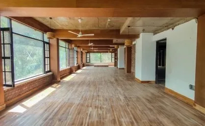 The empty yoga hall with wooden floors and tall windows