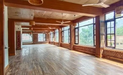 Sunlit yoga hall with brick walls and green views