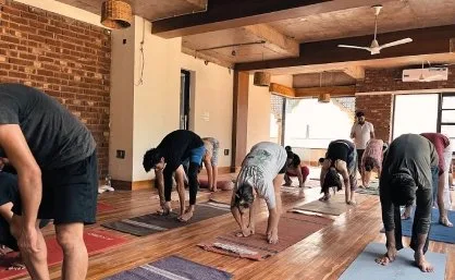 Students folding forward during a class in the hall