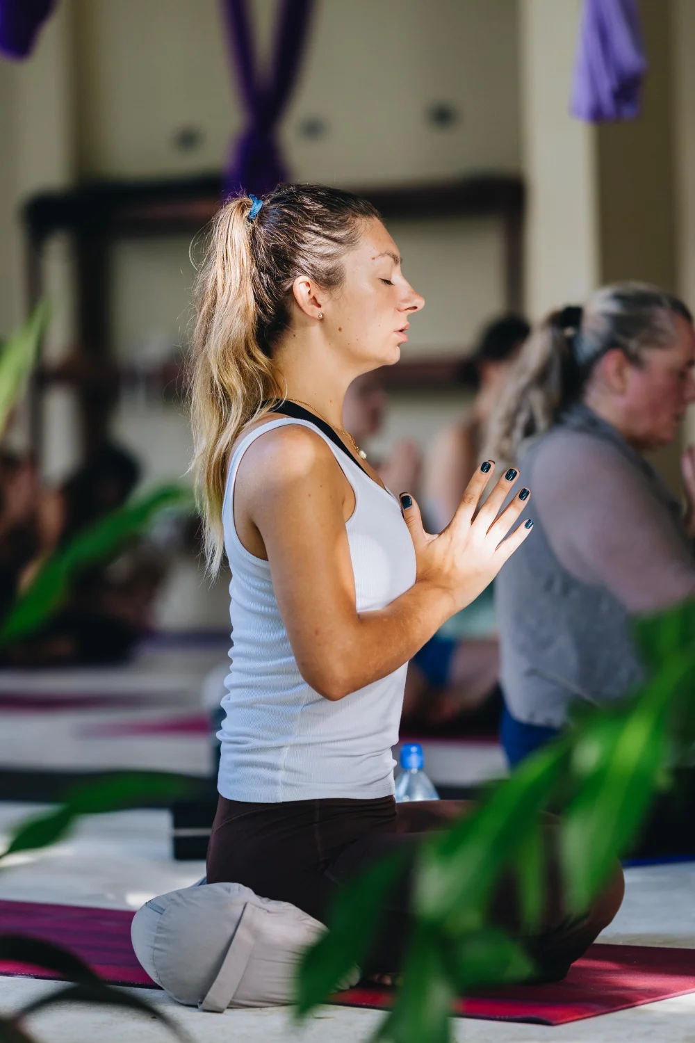 A student in a kneeling pose with a hand on her heart