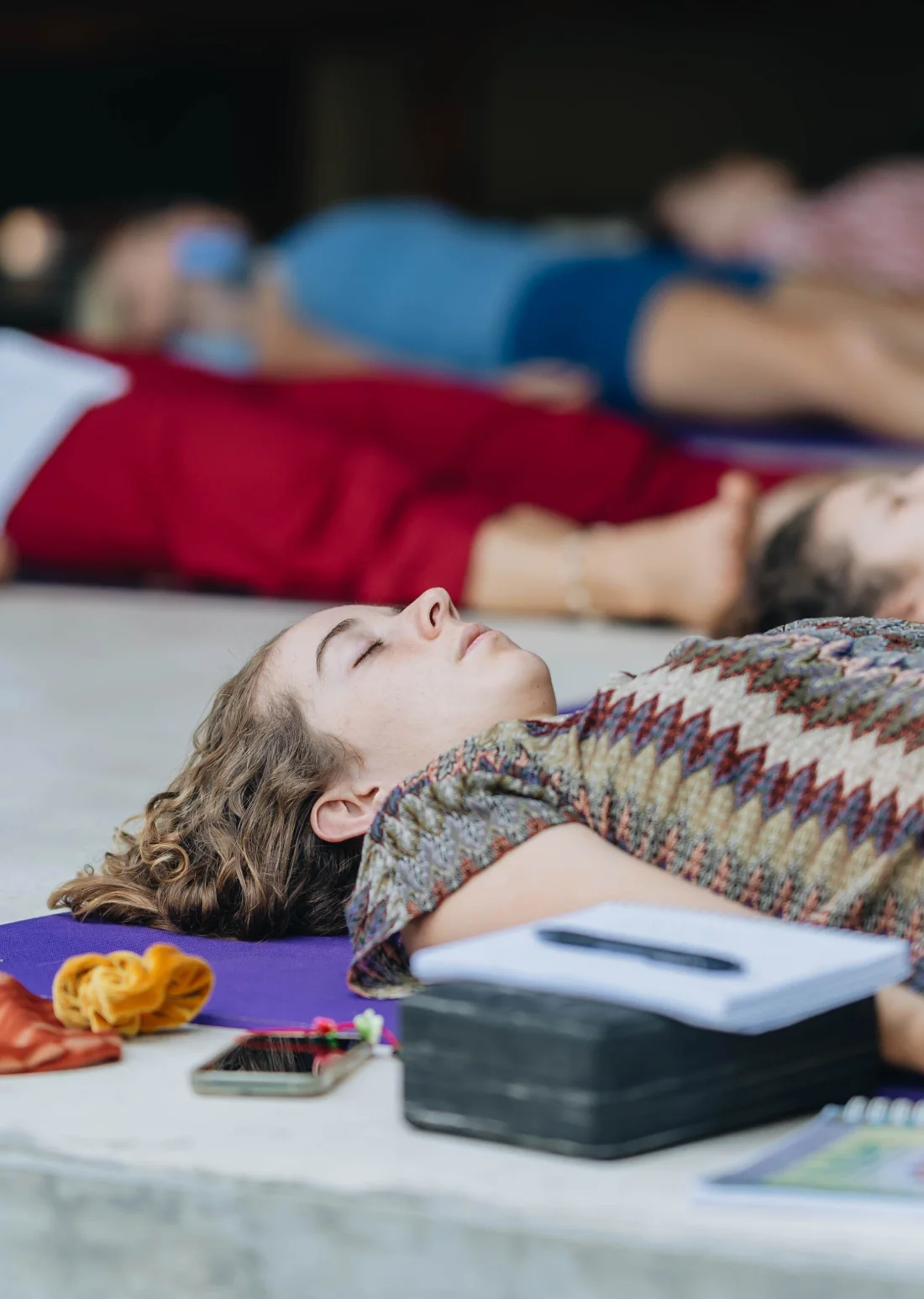Students resting in savasana after practice