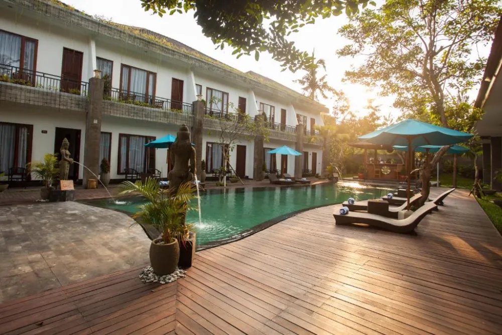 Swimming pool and rooms of the school accommodation in Ubud at sunset