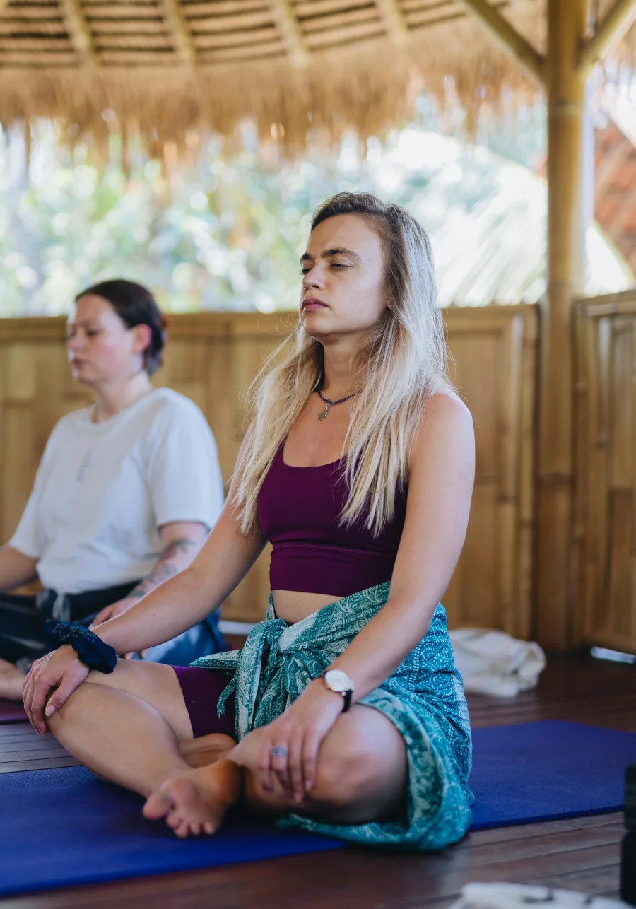 Students sitting in meditation inside a bamboo shala