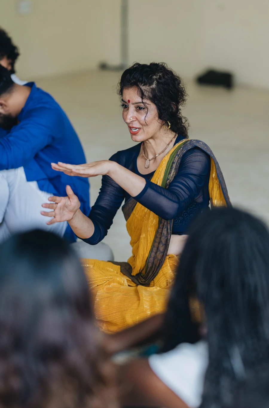 Maa Haripriya explaining a practice to students seated on the floor
