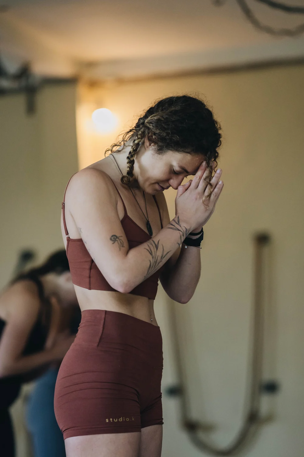 A student bowing her head to joined hands during practice