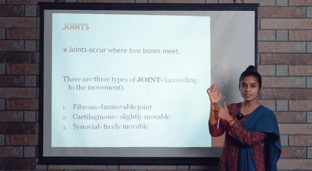 A teacher explaining the types of joints in an anatomy class