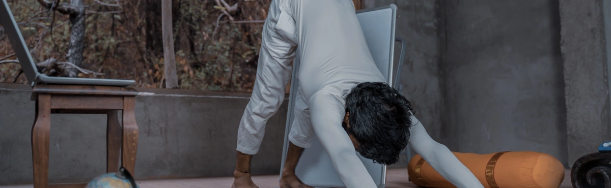 A student in downward facing dog by the laptop
