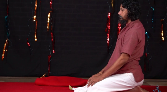 Yogi Vishnu seated in meditation on a red mat