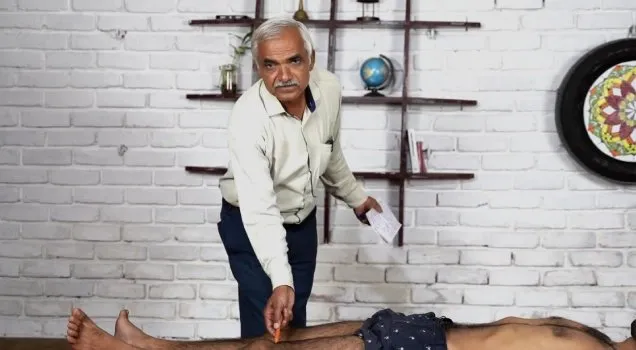 An Ayurveda teacher demonstrating a massage therapy technique