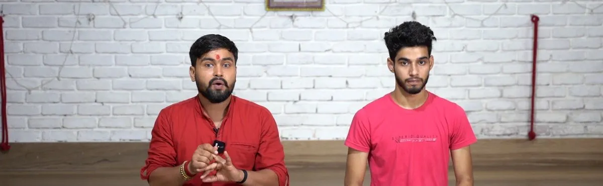 A Hatha Yoga teacher explaining a practice beside a student