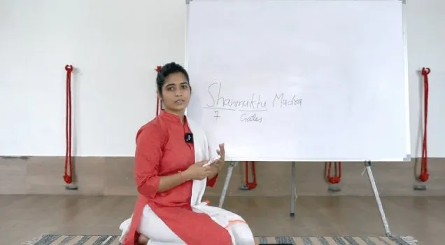 A teacher explaining Shanmukhi Mudra at a whiteboard