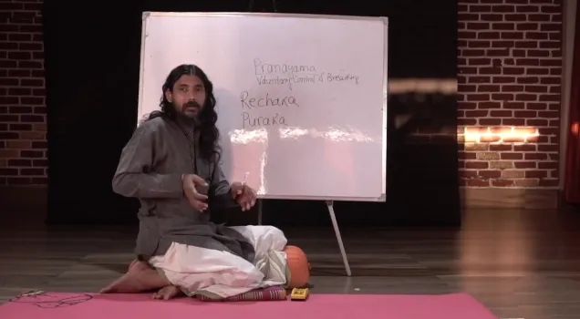 A teacher explaining Rechaka and Puraka at a whiteboard