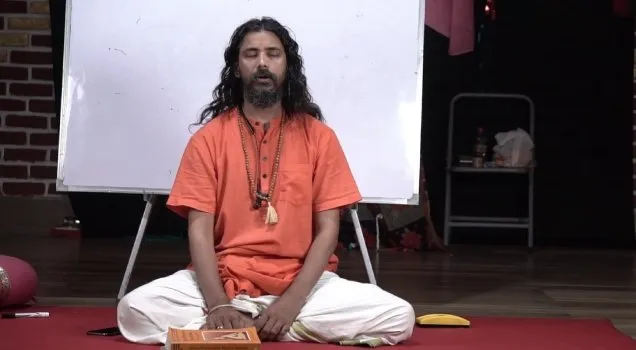 A teacher seated in meditation during a pranayama class