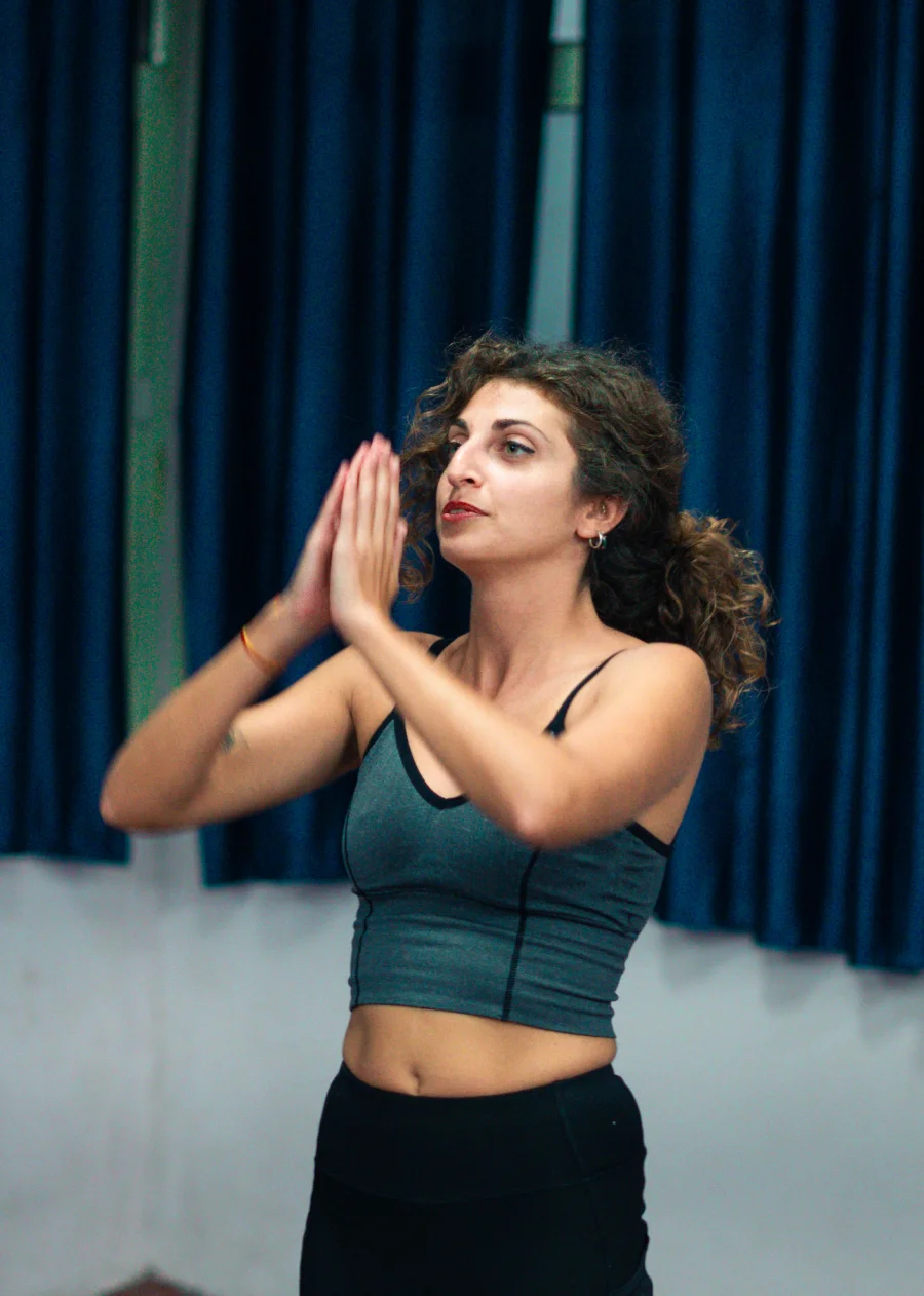 A student with palms joined during an indoor class