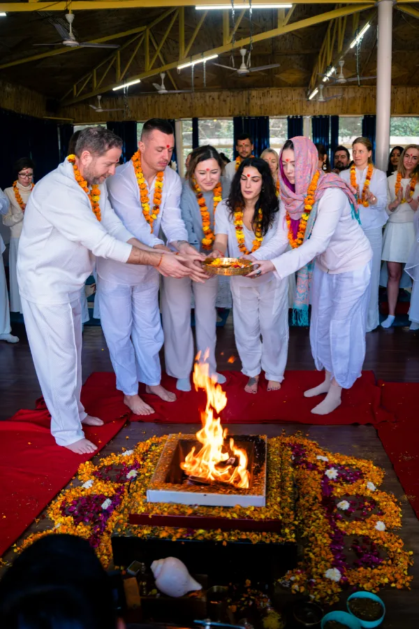 Students in white with marigold garlands offering to the sacred fire