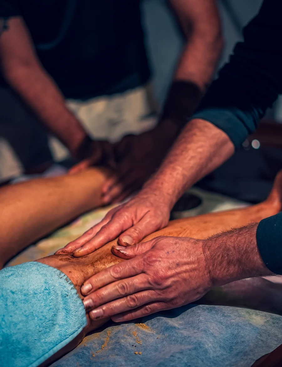 Therapists giving an Ayurvedic herbal leg massage