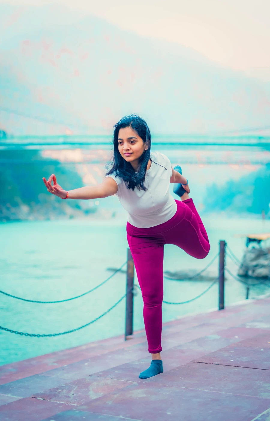 A student balancing on one leg on the ghat beside the Ganga