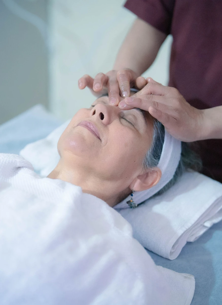 A therapist giving a gentle Ayurvedic head massage