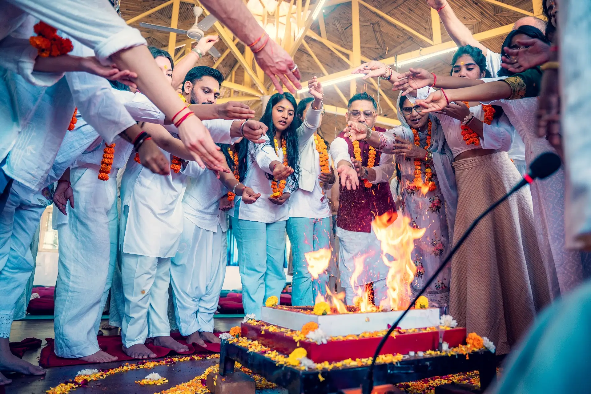 Students in white offering to the sacred fire during a havan ceremony