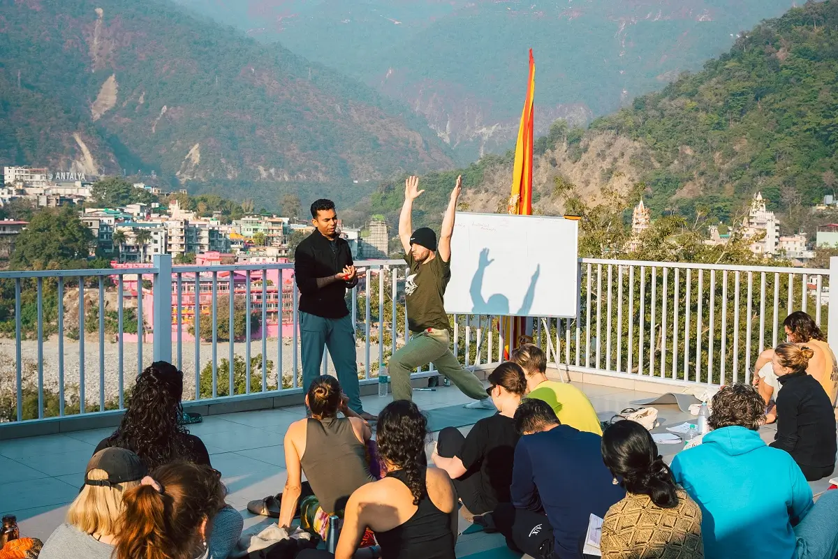Students practising together on the Ganga beach during a wellness retreat in Rishikesh