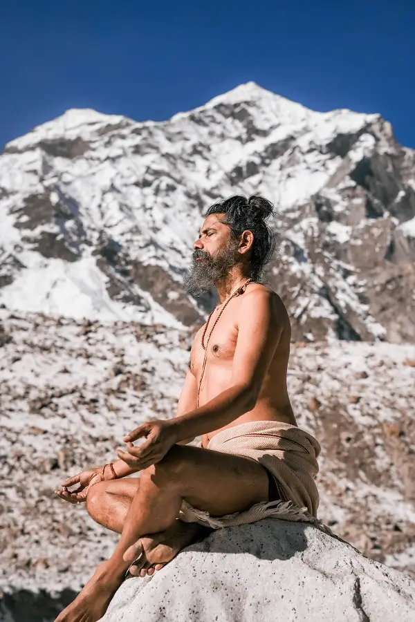 A yogi meditating beneath snow peaks