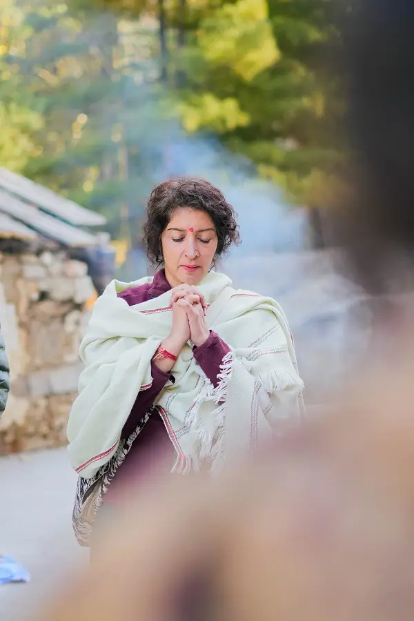 A participant in prayer at a mountain camp