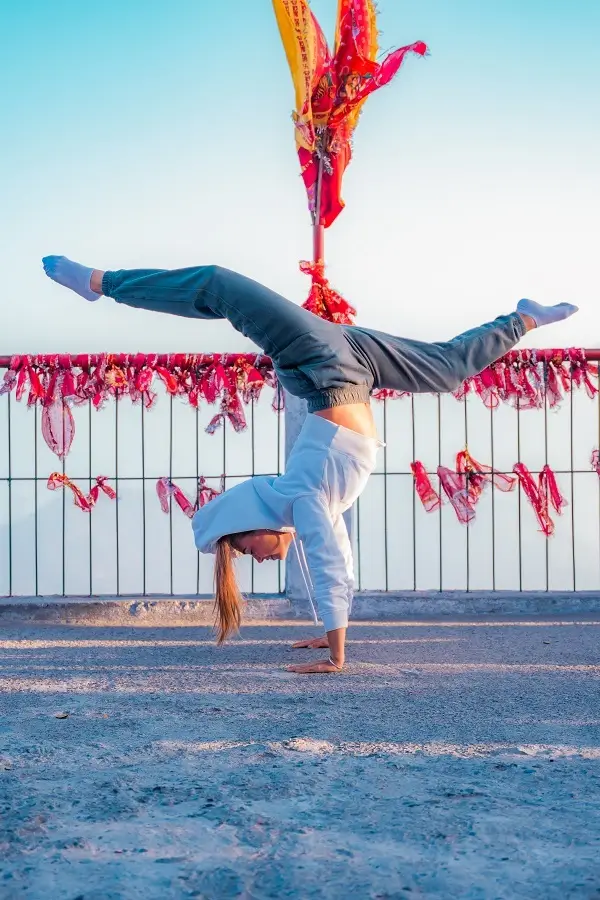 A student in a handstand at a Himalayan shrine on the trail