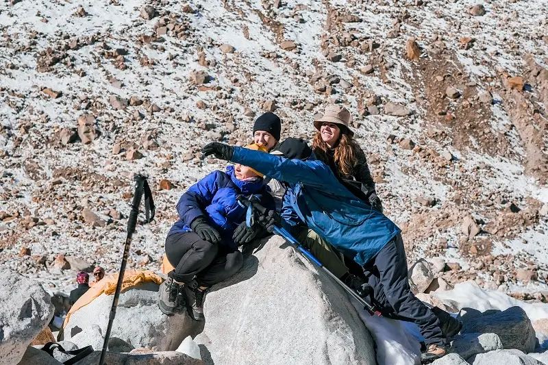 The group sitting together on a rocky mountain slope