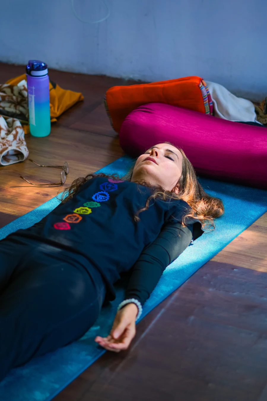 A student lying on a mat in deep relaxation during Yoga Nidra