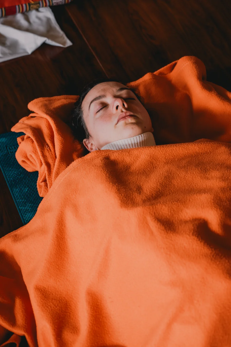 A student wrapped in an orange blanket in deep relaxation