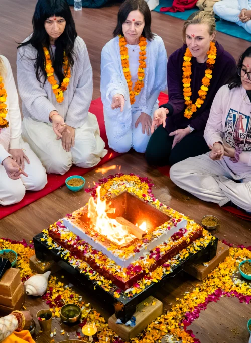 Students seated around a flower-decorated havan kund during a Mahavidya ritual