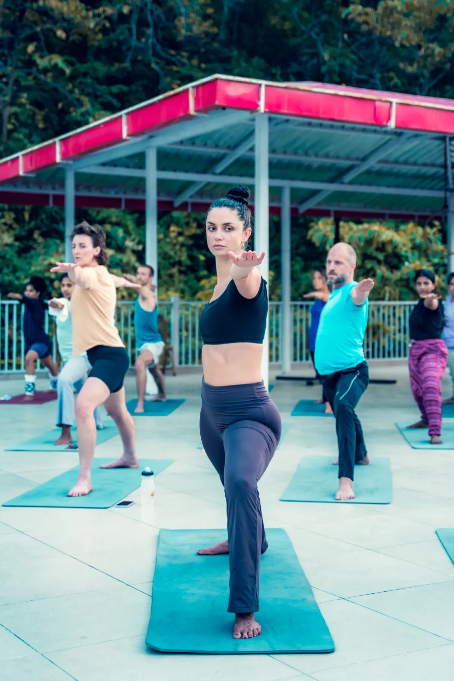 Students holding warrior pose together on the open-air yoga deck