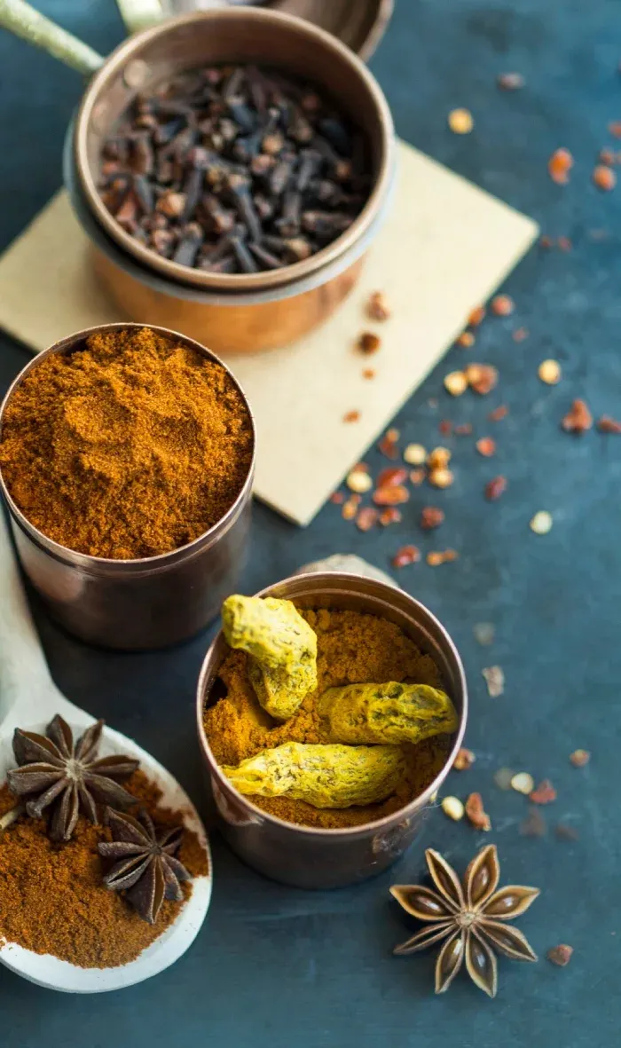 Bowls of cloves, turmeric, and whole spices with star anise