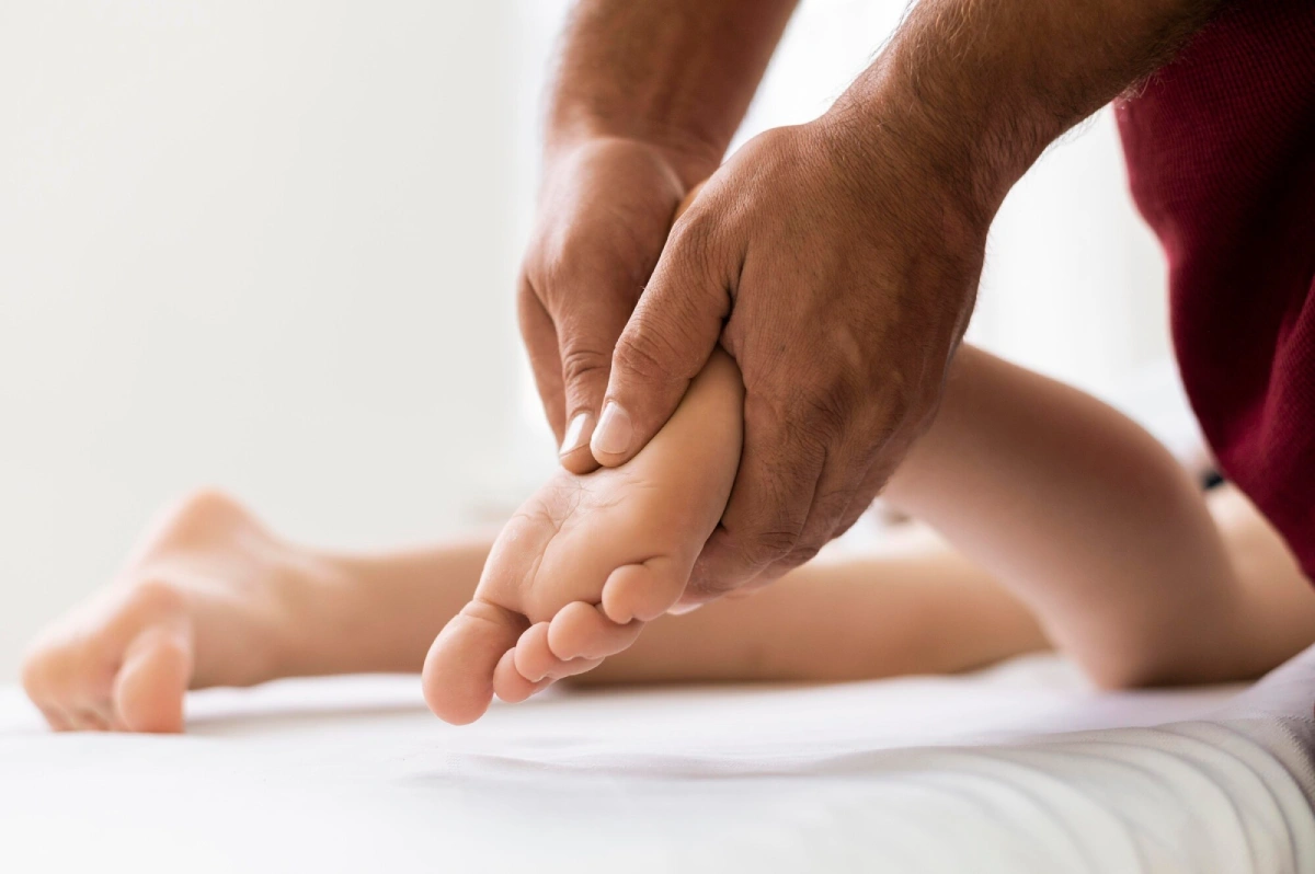 A therapist pressing reflex points on the sole of a guest&rsquo;s foot