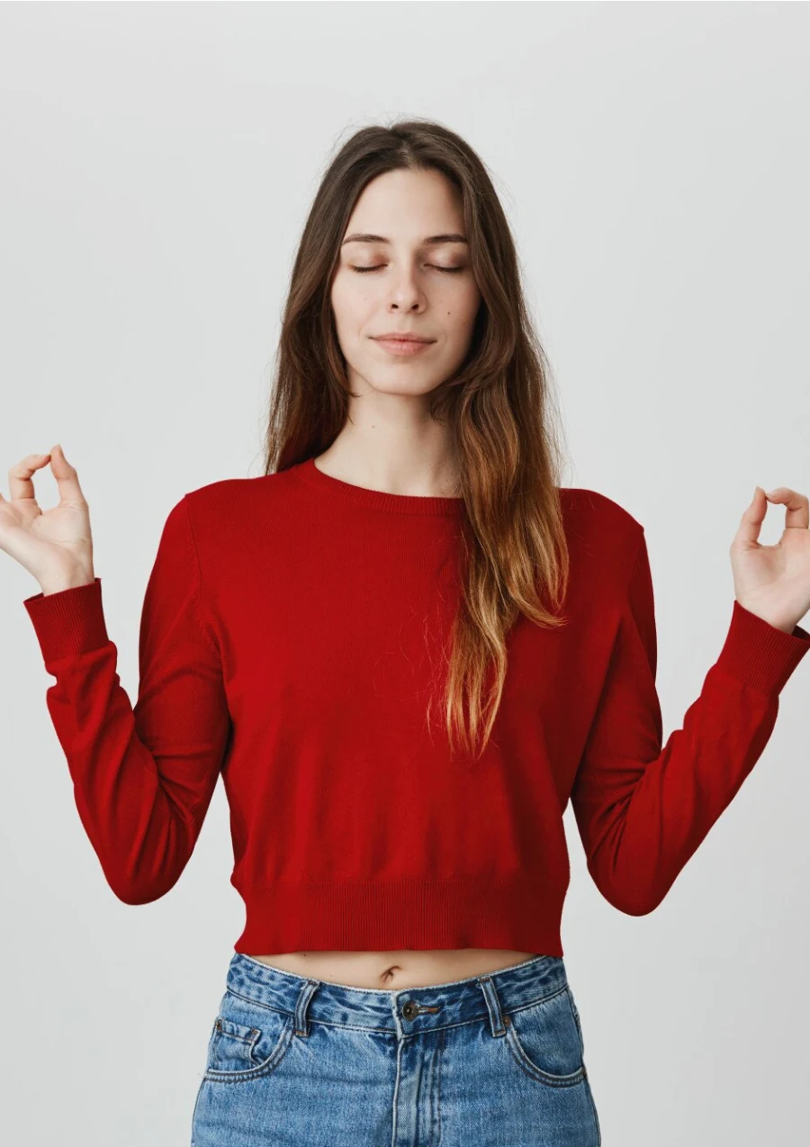 A woman with eyes closed holding her hands in a meditation mudra