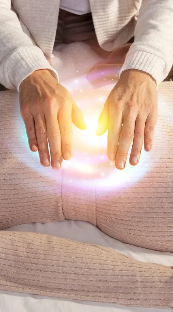A healer’s hands hovering over glowing energy above the body