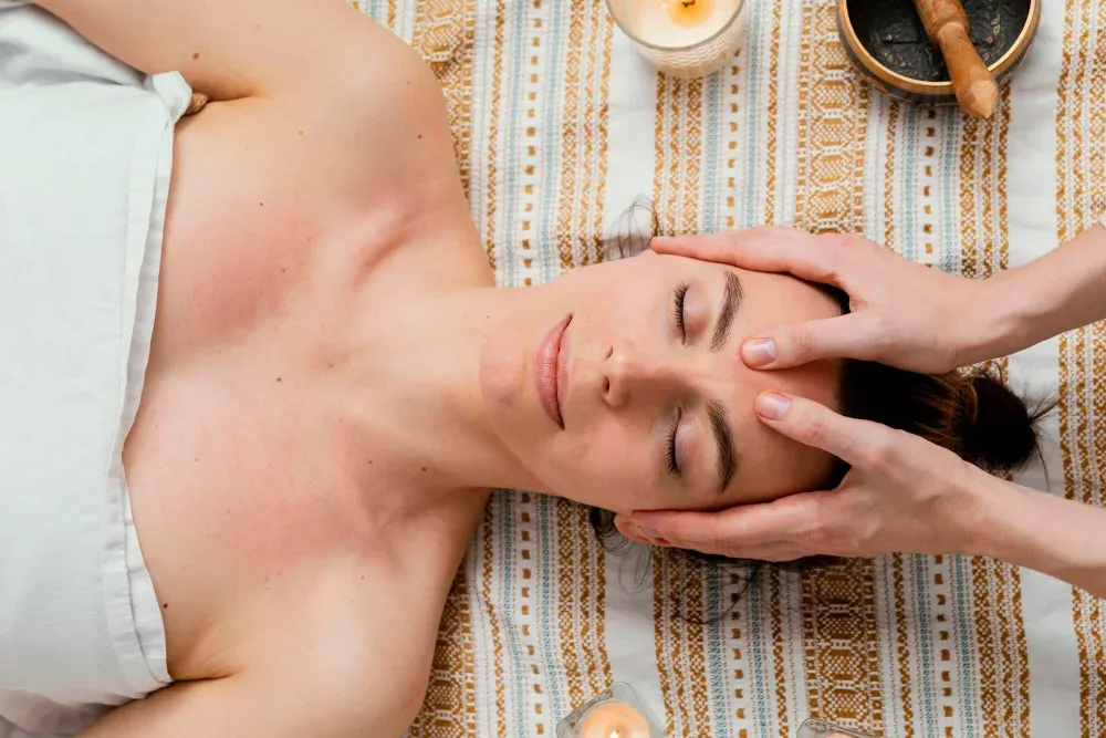 A healer&rsquo;s hands cradling a resting woman&rsquo;s head