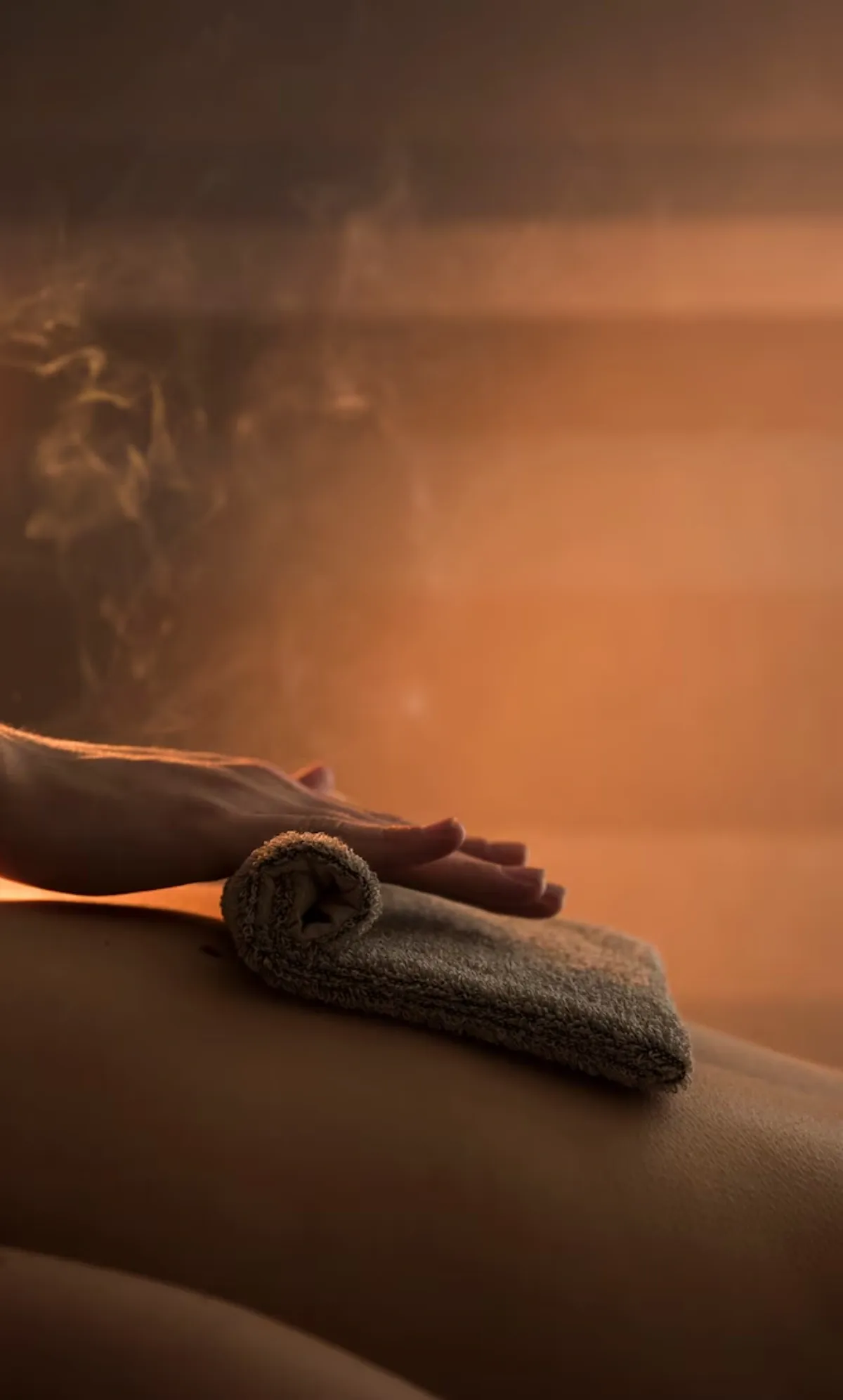 A hand resting on a folded towel during a spa treatment