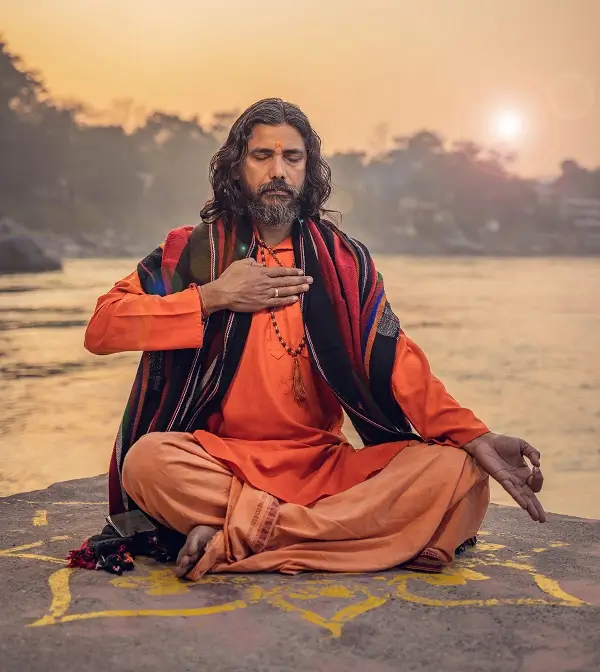 Yogi Vishnu Panigrahi meditating by the Ganges at sunset