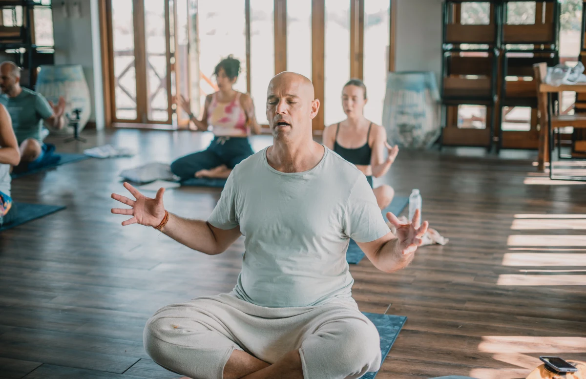 A student in seated breathwork with open palms during a kundalini class