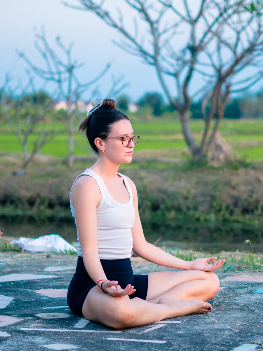 A student meditating cross-legged outdoors in Chiang Mai