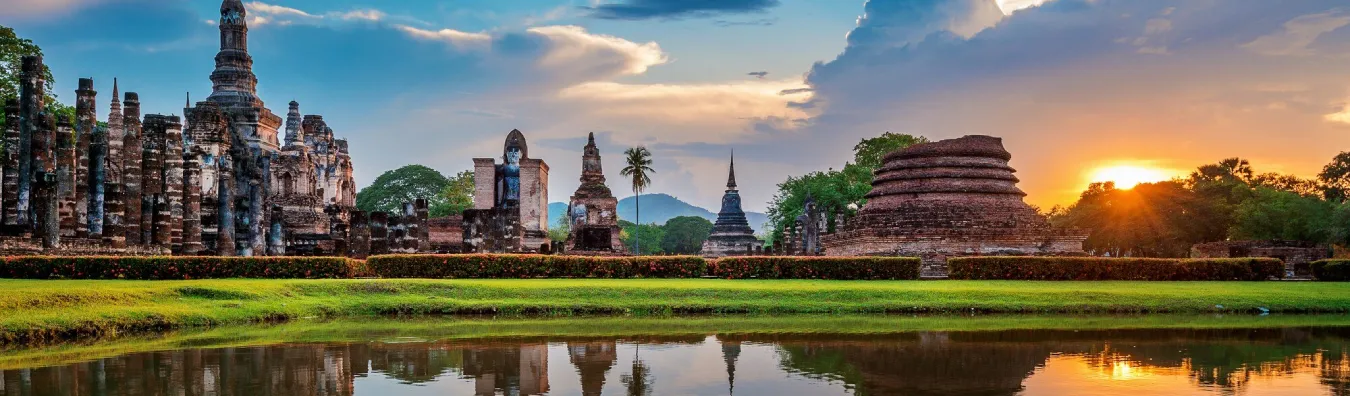 Ancient temple ruins in Thailand reflected in water at sunset