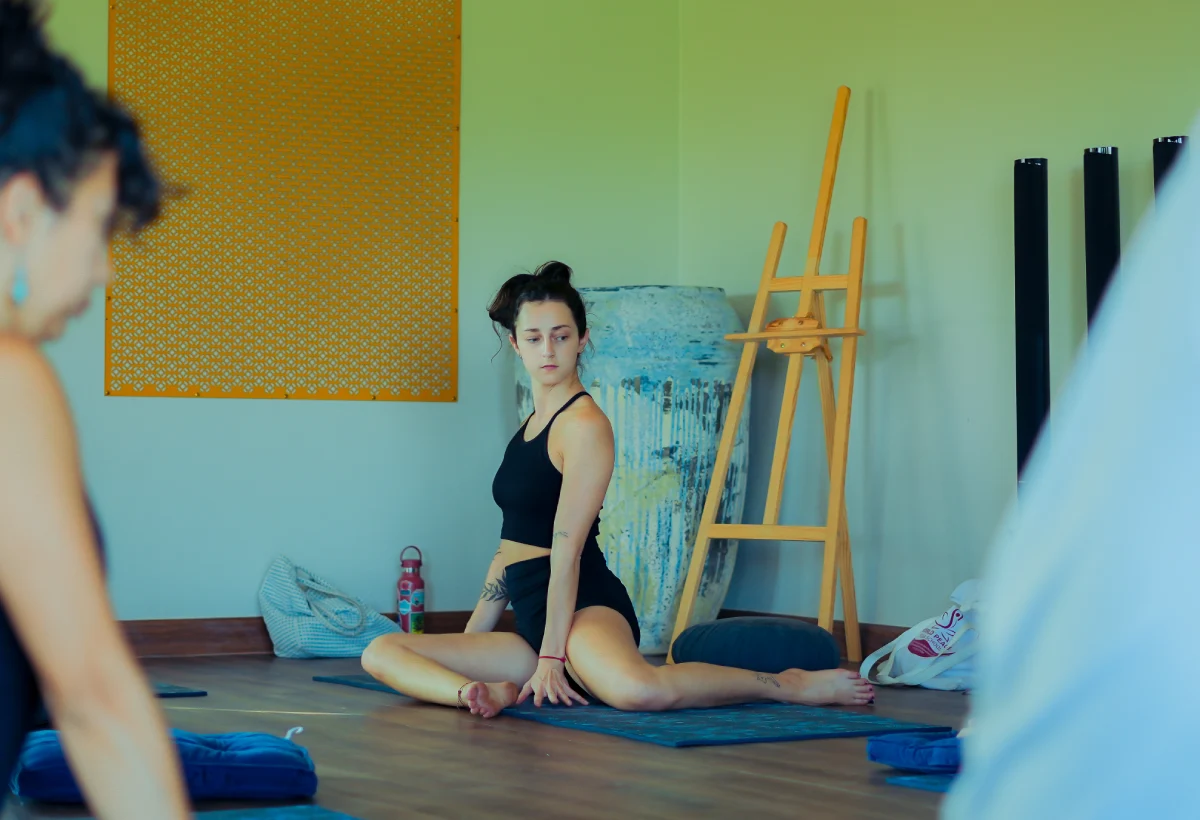 A student in a seated twist on her mat in the Chiang Mai yoga hall